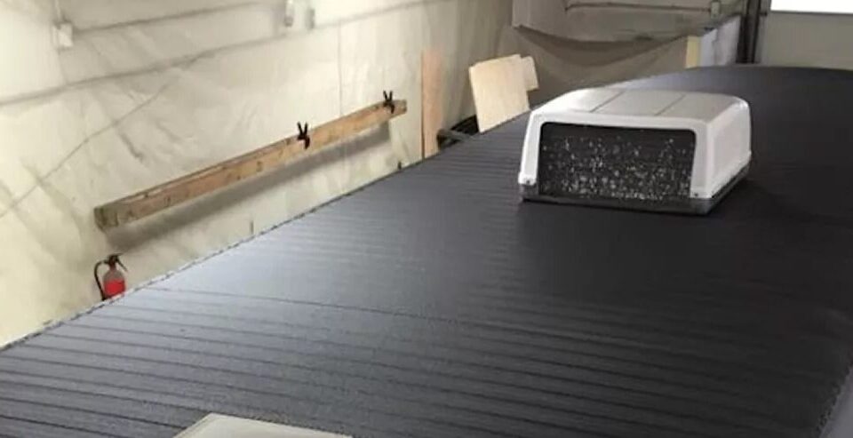 Trailer roof sprayed with a black monolithic polyurea membrane