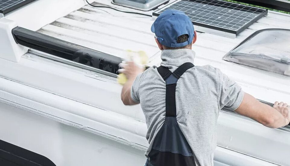 Technician inspecting seams and vents on an RV roof