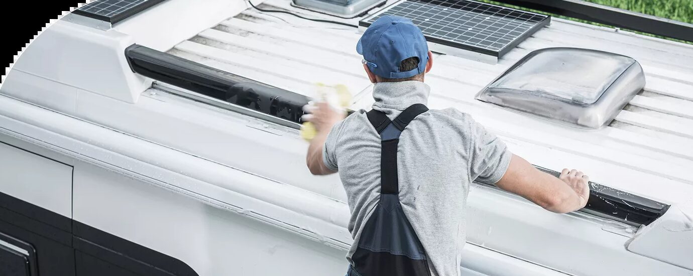 Technician inspecting seams and vents on an RV roof